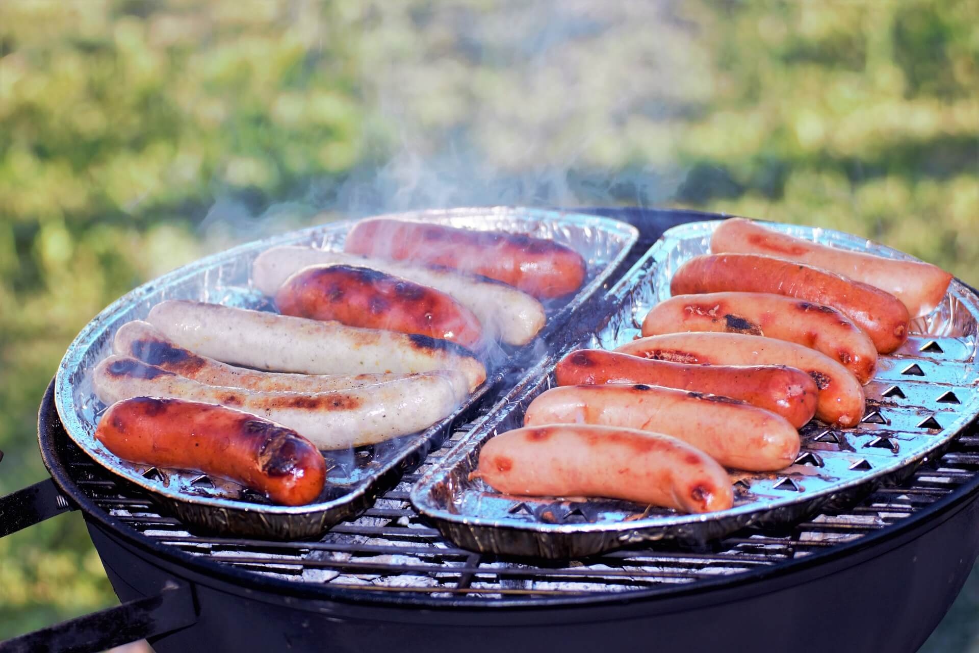 hotdogs cooking on a grill