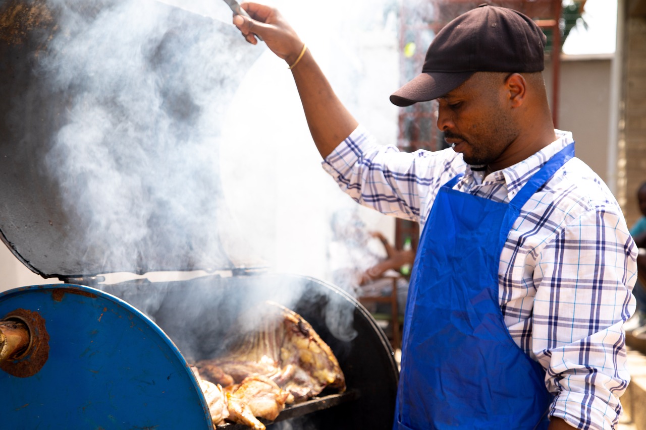 man grilling food in blue apron