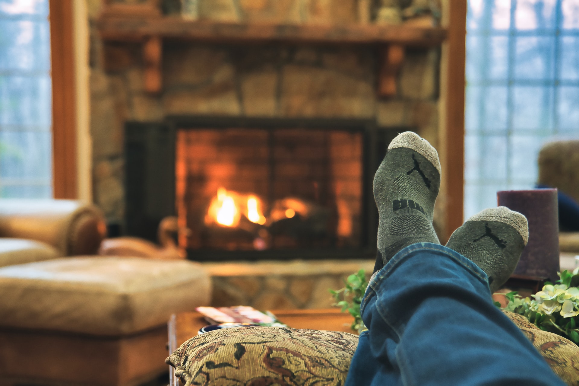 Person resting their feet on a table in front of the fireplace