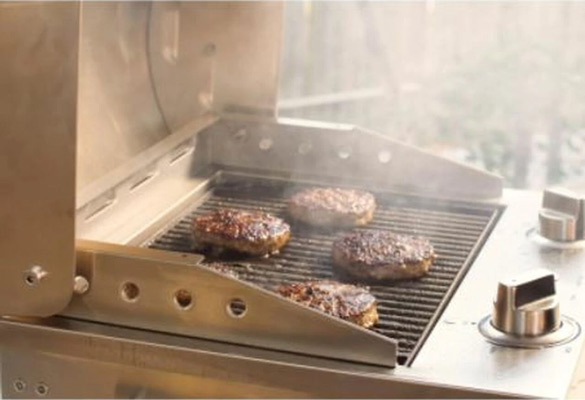 Portable electric grill by Coyote with burger patties being grilled on top
